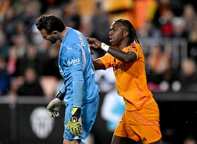 Real Madrid's Vinicius Jr clashes with Valencia keeper Stole Dimitrievski before he is shown a red card. Reuters