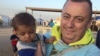 British aid worker, Alan Henning, holding a child in a refugee camp on the Turkish-Syrian border before he was taken hostage and murdered by Isis. AFP