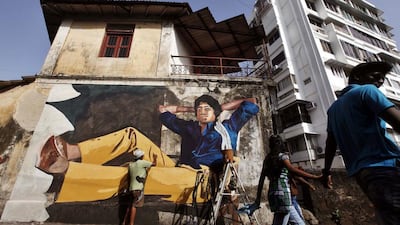Street artist Ranjit Dahiya works on a mural depicting Bollywood actor Amitabh Bachchan. AP Photo