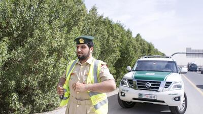 First Lieutenant, Mohammad Al Badwawi walks towards a car parked on side of Sheikh Mohammed bin Zayed Road. Reem Mohammed / The National