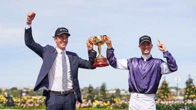 Jye McNeil and stable representative Mark Power celebrate with the trophy after their horse, Twilight Payment, won the Melbourne Cup. AFP