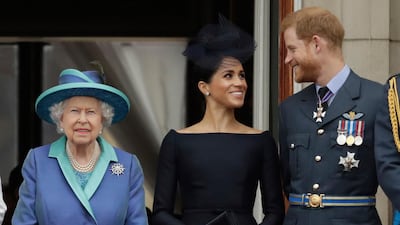 Britain's Queen Elizabeth II, Meghan the Duchess of Sussex and Prince Harry watch a flypast of Royal Air Force aircraft pass over Buckingham Palace in London. AP Photo