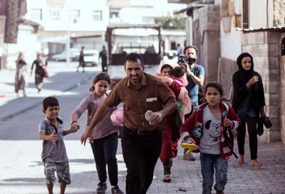 People run to take cover after mortars fired from Syria, in Akcakale, Turkey, Thursday, October 10, 2019. AP
