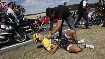 Race leader Fabian Cancellara of Switzerland receives assistance as he lies on the ground after a fall during the 159.5-kilometre third stage yesterday. Eric Gaillard / Reuters