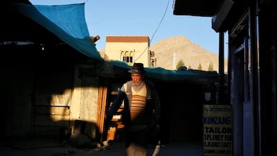 A man walks past shops as the sun sets in Leh, the largest town in the region of Ladakh, nestled high in the Indian Himalayas.