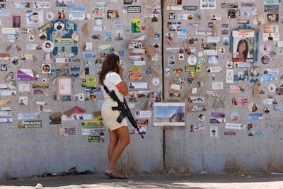 An Israeli woman walks past posters on a bomb shelter in the southern Reim kibbutz. Reuters