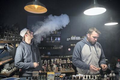A man exhales vapour produced by an e-cigarette in a UK vaping shop. Getty Images
