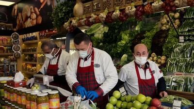 People wearing masks to help protect against the spread of coronavirus, work at a food market hours before a two-day weekend nationwide lockdown, in Ankara, Turkey, Friday, April 16, 2021. AP
