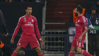 Cristiano Ronaldo, left, strikes his typical celebratory pose after heading Real Madrid into the lead against Schalke. Wolfgang Rattay / Reuters