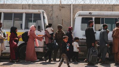 People preparing to leave Afghanistan board buses going to Hamid Karzai International Airport in Kabul on August 22. Photo: AFP