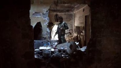 A Free Syrian Army fighter stands inside a burnt house in Deir Al Zor.