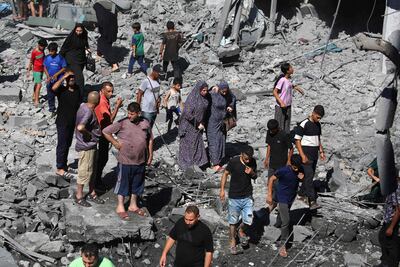 Palestinians amid the rubble after an Israeli strike on the Al Bureij camp in central Gaza. AFP