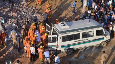 Members of the National Disaster Response Force (NDRF) remove a victim from the rubble. AFP