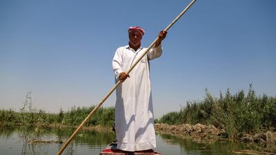 The chief of the local fishermen's union sails across the Delmaj marsh, in Iraq's southern province of Diwaniyah. AFP