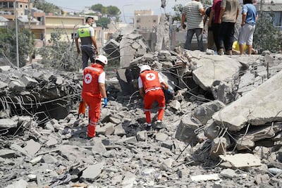 Lebanese rescue workers at the scene of the Israeli strike on Deir Al Zahrani. AFP