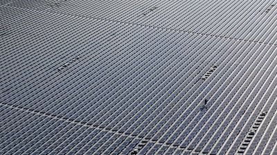 An engineer walks between panels on the Yamakura Dam floating solar plant in Ichihara, Japan. Getty Images