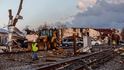 Workers remove debris blocking railroad tracks in Selma. AP