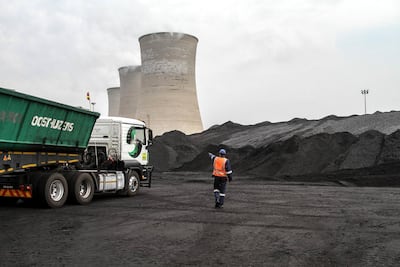 A worker supervises as a truck delivers coal supplies to the coal yard at the Grootvlei power station, operated by Eskom Holdings SOC Ltd., in Grootvlei, South Africa, on Monday, Nov. 3, 2014. Eskom said South Africa's power supply remains strained as it investigates what caused a silo storing coal to collapse, forcing the state-owned utility to cut electricity to customers. Photographer: Dean Hutton/Bloomberg
