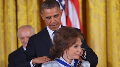 US President Barack Obama presents the Presidential Medal of Freedom to country music star Loretta Lynn in 2013. AFP