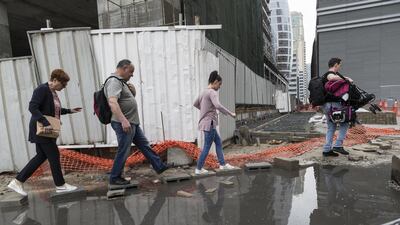 Residents of Barsha Heights navigate a flooded street. Antonie Robertson / The National