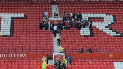 Fans leave the Stretford End during the evacuation of both the Sir Alex Ferguson stand (unseen) and the Stretford stands ahead of the Premier League match between Manchester United and Bournemouth at Old Trafford in Manchester, north west England, on May 15, 2016. Oli Scarff / AFP
