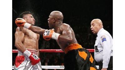 Floyd Mayweather Jr lands a controversial knockout punch to Victor Ortiz as referee Joe Cortez, right, watched on during their WBC Welterweight bout in Las Vegas. John Locher / AP Photo