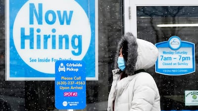 A woman walks past a help wanted sign displayed at a CD One Price Cleaners in Schaumburg, Illinois. AP