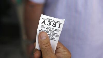 A customers holds a ticket number while waiting for permission to enter an open branch of Piraeus Bank in Athens. Simon Dawson / Bloomberg