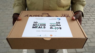 A worker holds a food pack from Dubai's Beit Al Khair Society, as part of the Ruler of Dubai's 2020 campaign to deliver 10 million meals to low income residents. This year, the campaign will expand to 100 million meals in 20 countries in the region. All photos by Pawan Singh / The National