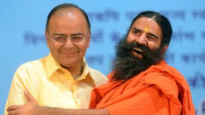 Indian yoga guru Baba Ramdev (R) greets Bharatiya Janata Party senior leader Arun Jaitley during Ramdev’s Pledge Completion rally in New Delhi, India. Raveendran / AFP