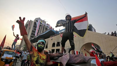 Protesters flash the victory sign and pose with national flags at the end of Al Jumhuriya Bridge. AFP