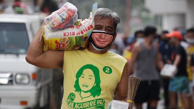 A resident carries relief goods in his village damaged by Typhoon Vamco in Marikina, Philippines. The typhoon left dozens of people dead as it swelled rivers and flooded low-lying areas while it passed over the capital, Manila, and storm-battered northeast Philippines. AP Photo