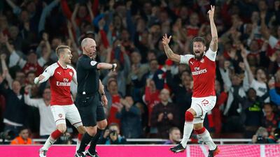 Arsenal's Olivier Giroud celebrates as referee Mike Dean, centre, says the ball has crossed the line for a goal during their English Premier League soccer match between Arsenal and Leicester City at the Emirates stadium
