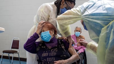 Nurses from Humber River Hospital administer the Pfizer-BioNTech Covid-19 vaccine to Maria DiStefano as her husband Vince DiStefano looks on, at St Fidelis Parish in Toronto, Ontario, Canada. Reuters