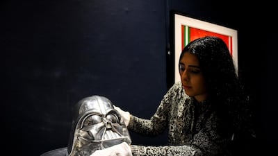 A Sotheby's employee holds a Head of Card Vader of 1999 as part of the Star Wars auction in London. Sotheby's will now host its second sale dedicated to 'Star Wars' collectibles, titled 'Star Wars Online'. AP Photo