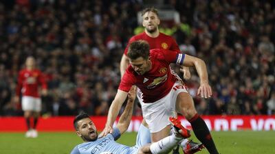 Manchester City's Sergio Aguero, left, in action with Manchester United's Michael Carrick. Jason Cairnduff / Reuters