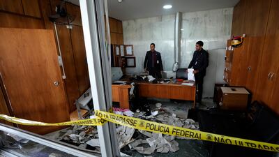 Agents inspect a room inside Planalto Palace, the office of the President. AP
