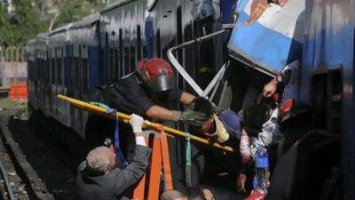 Firemen rescue wounded passengers from the commuter train after the collision in Buenos Aires, Argentina, yesterday. Leonardo Zavattaro, Telam / AP Photo