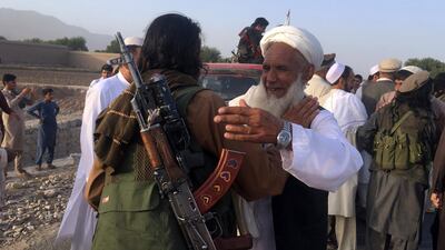 Afghan Taliban fighters and civilians greet each other during a brief truce for Eid Al Fitr in June 2017. AP Photo