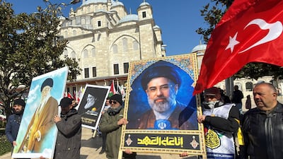 Protesters hold posters of Iran's late supreme leader Ayatollah Ali Khamenei and his son and successor, Mojtaba Khamenei, in Istanbul, Turkey. Reuters