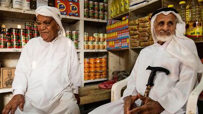 Ali Mohammed and Ali Obaid Humeid, both in their 60s, sit in their friend Mohammed Khasan's shop.