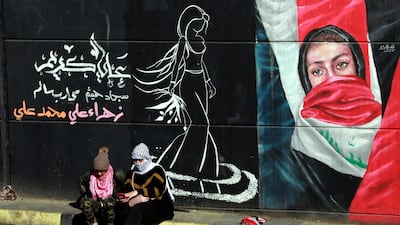 Female protesters sit next to a wall painted with a graffiti during ongoing anti-government protests at the Al Tahrir square in central Baghdad, Iraq. EPA