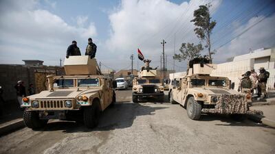 Iraqi army vehicles gather outside a building used by Iraqi security forces to check residents' ID cards in a search for Islamic State fighters in Mosul this week. Khalid Al Mousily / Reuters