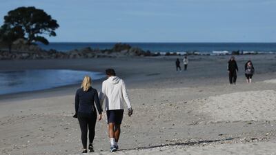 People walk on the beach in Cambridge, New Zealand. Getty Images