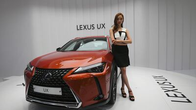 A model poses with a Lexus UX at the show. Jung Yeon-Je / AFP
