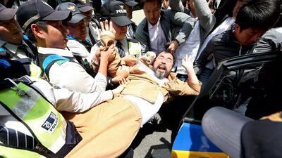 South Korean policemen detain a protester during a rally against the Japanese government in front of the Japanese Embassy in Seoul, South Korea. Jeon Heon-Kyun / EPA