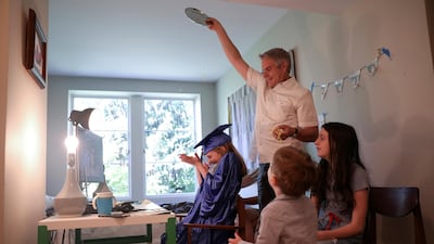 Doug Hassebroek pours confetti over his daughter Lydia, celebrating her graduation ceremony at their home during the outbreak of coronavirus disease in Brooklyn, New York, USA. Reuters