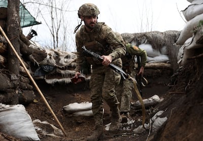 Ukrainian soldiers walk in a trench on the front line with Russian troops in Luhansk region awaiting the Russian offensive in eastern Urkaine. (Photo by Anatolii STEPANOV / AFP)