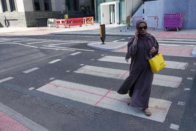 A pedestrian at a zebra crossing marked with St George's crosses near the Britannia International Hotel in Canary Wharf, where protests have been held against plans to accomodate migrants. Photo by CARLOS JASSO / AFP