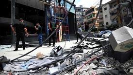 A shopkeeper has his store repaired after Israeli military strikes on the southern Lebanese coastal city of Tyre. Job losses in the country have been distributed unevenly across economic sectors. AFP